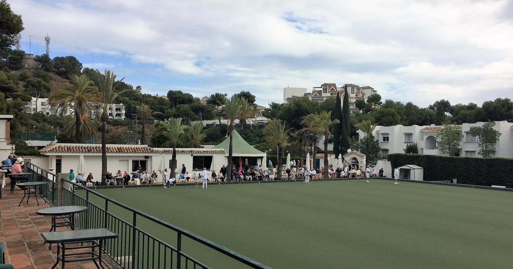 Panoramic view of the Miraflores Bowls Club green with the clubhouse and palm trees